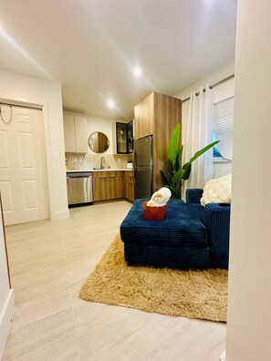 A modern kitchen with stainless steel appliances, a wooden cabinet, and a large window. - Cozy 1-bedroom apartment in fantastic Fort Lauderdale with AC (Fort Lauderdale)