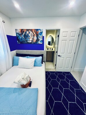 A hotel room with a bed, a painting on the wall, a bathroom with a mirror, and a door. - Cozy 1-bedroom apartment in fantastic Fort Lauderdale with AC (Fort Lauderdale)