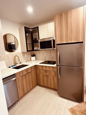 A modern kitchen with a stainless steel refrigerator, a microwave, and a dishwasher. - Cozy 1-bedroom apartment in fantastic Fort Lauderdale with AC (Fort Lauderdale)