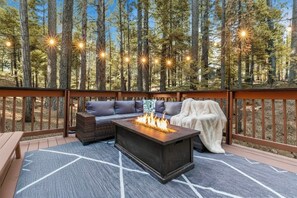 An outdoor deck with a fire feature, seating, and string lights. - Escape to Sequoia Grove Lodge! Modern 4BR/3BA BLS cabin with flat entry, new kitchen, game loft arcade, bunk room, and A/C. Walk 5 mins to private lake & golf; between Big Trees & Murphys. Perfect luxury retreat for multi-family & multi-gen groups! (Arnold)