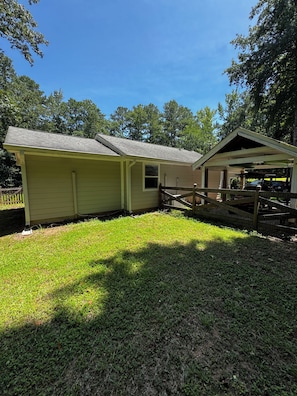 A single-story building with a covered porch and a fenced-in area.