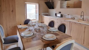 Comedor con mesa de madera dispuesta para seis personas, rodeada de sillas con asientos acolchados.
