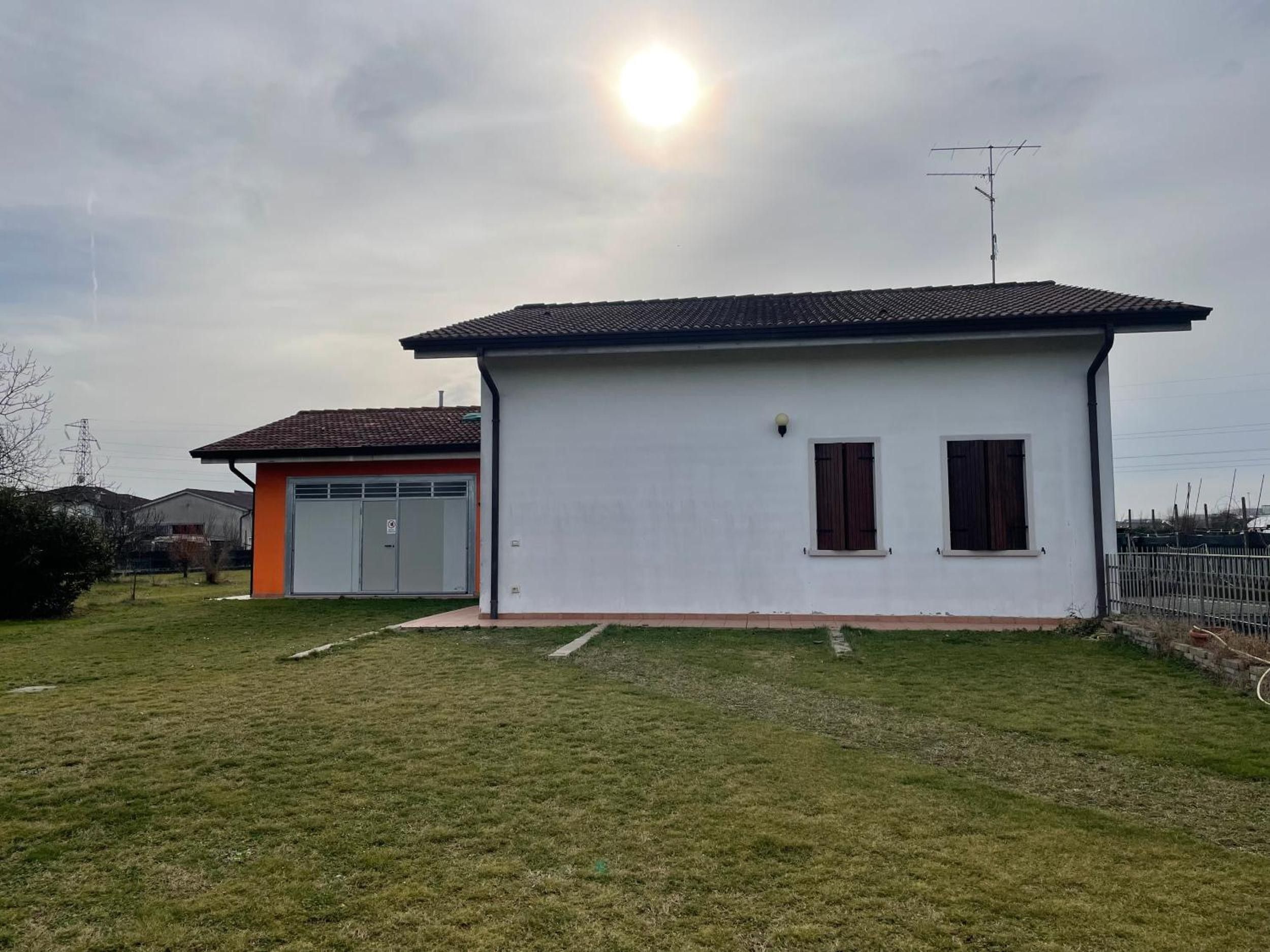 Ein eingeschossiges Haus mit Garage, kleinem Rasen und blauem Himmel.
