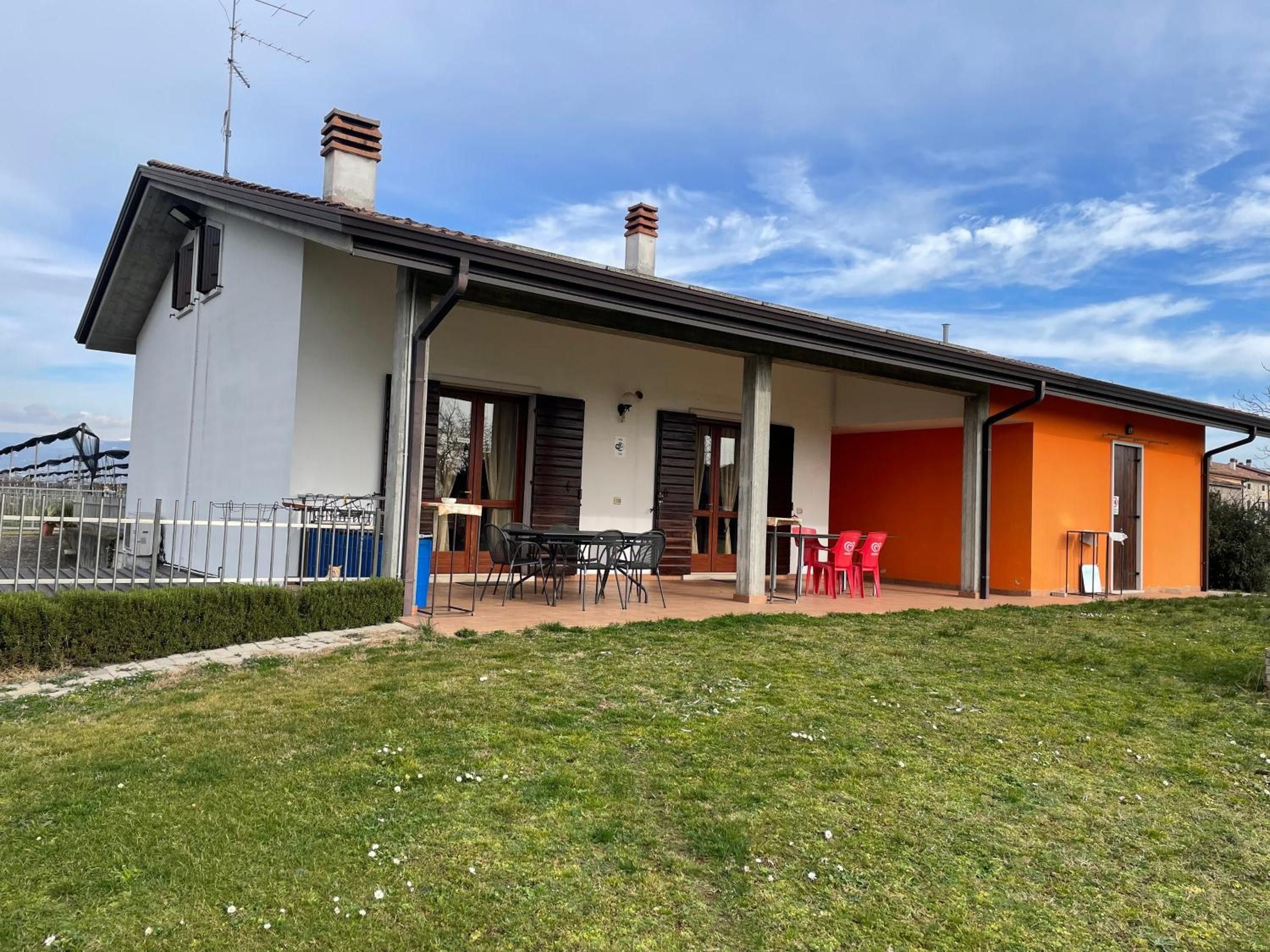 Une maison à deux étages dotée d’un patio couvert.