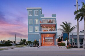 A multi-story residential building with a balcony and a garage entrance. - Salty Seahorse (Fort Myers Beach)