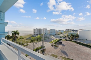 A coastal view with buildings, a beach, and palm trees. - Salty Seahorse (Fort Myers Beach)