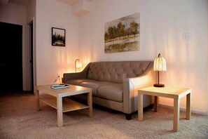 A living room with a sofa, two tables, and two wall-mounted lamps. - Escape to beautiful Lake Anna in this spacious amenity loaded retreat! (Mineral)