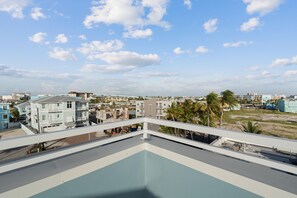 Ein Pool auf dem Dach mit Blick auf eine Küstenstadt.