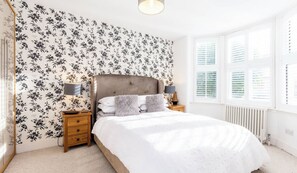 A bedroom with a bed, nightstands, a lamp, and a window with blinds. - West London Period Property w Access to Airports and Central London (London)