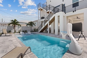 A swimming pool with a basketball hoop, a slide, and a staircase leading to an upper level. - Calico Jack's Lookout (Fort Myers Beach)