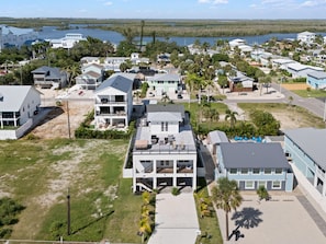 A coastal residential area with multiple two-story houses, some with balconies, and a beach in the background. - Calico Jack's Lookout (Fort Myers Beach)