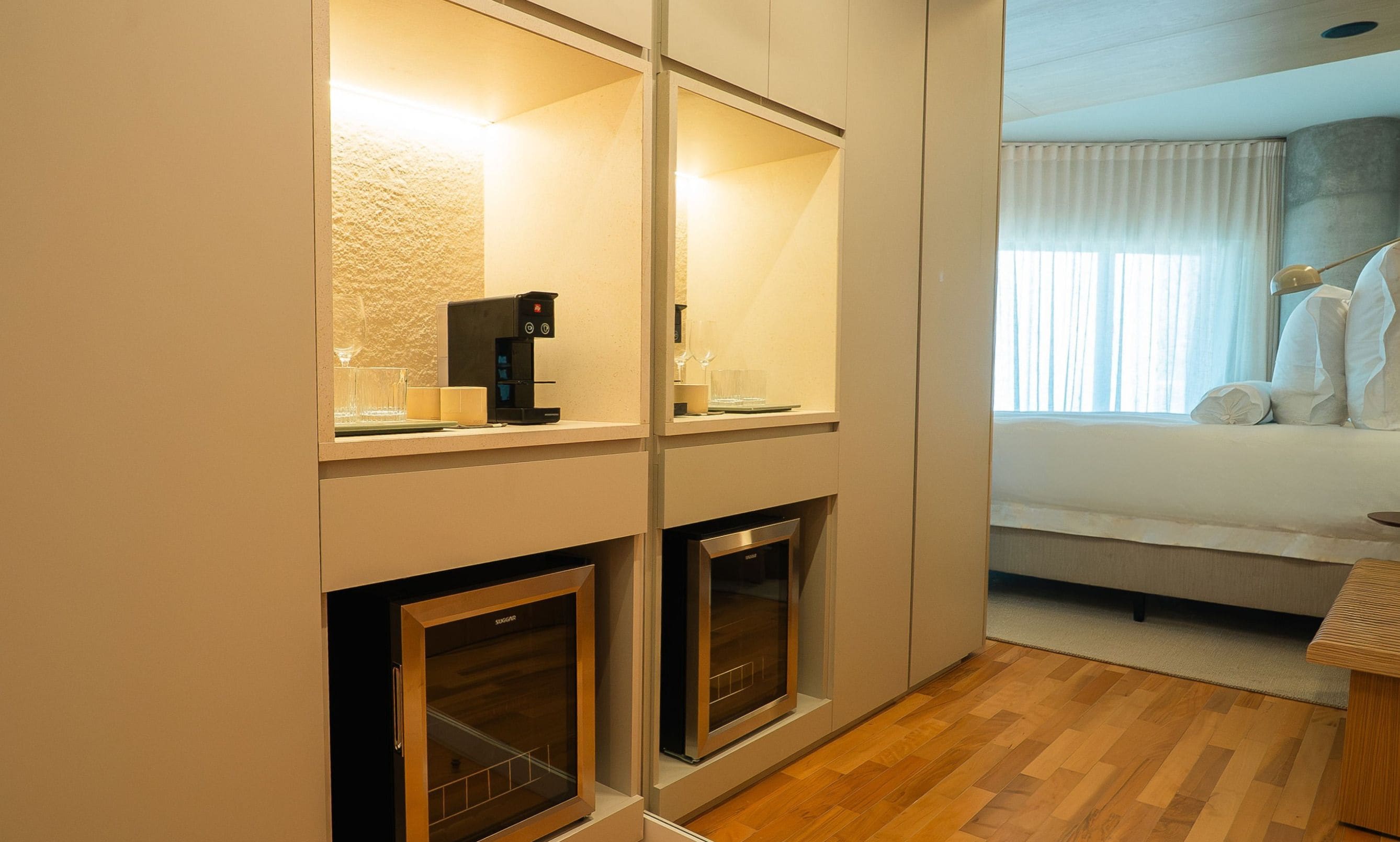Una habitación de hotel con cama, mesita de noche, lámpara y chimenea, junto con una cafetera.