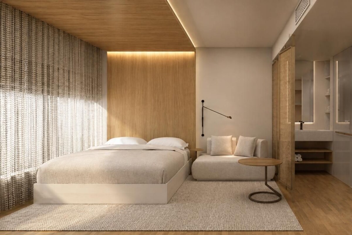 A modern bedroom with a bed, a sofa, a small round table, and a wardrobe.