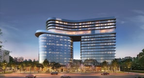 A modern hotel with a curved facade, multiple floors, and a glass exterior. - V3rso Nilo Square (Porto Alegre)