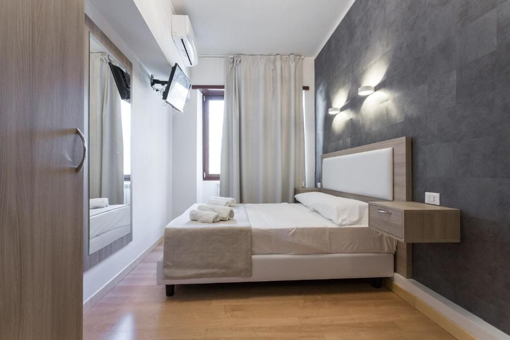 A modern bedroom with a bed, bedside table, and a wall-mounted TV.