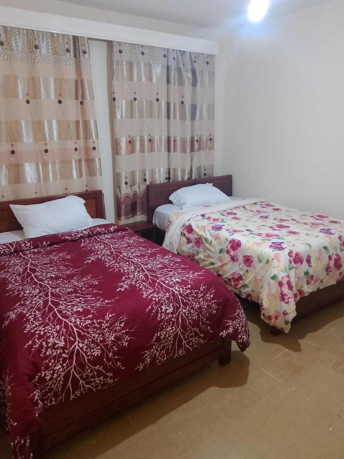 A room with two beds, each with a different patterned bedspread.