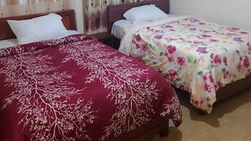 A room with two beds, each with a different patterned bedspread.