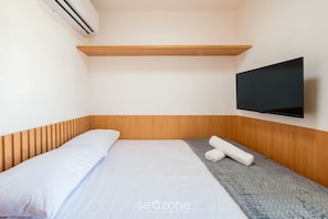 A neatly made bed with white linens, a grey textured blanket, and a wooden headboard. A flat-screen TV is mounted on the wall above the bed. - Apt in Bldg w/ Pool, 280m From Beach Clf0104 (Salvador)