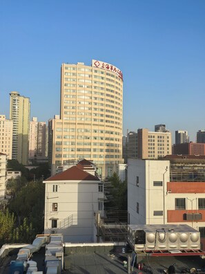 Un edificio de varios pisos con un letrero llamativo, rodeado de otros edificios altos.