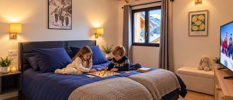 Un dormitorio con una cama grande, dos lámparas de noche, un televisor y una ventana con cortinas.