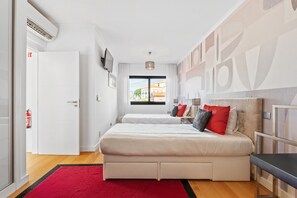 Une chambre d’hôtel moderne avec un grand lit, un tapis rouge et une vue sur la ville.