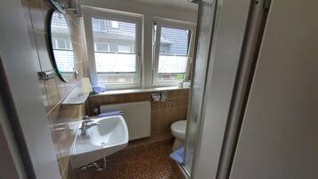 A bathroom with a sink, toilet, and shower.