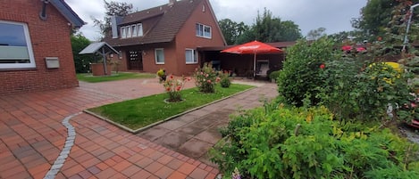 Un quartier résidentiel avec une allée pavée menant à une maison dont le toit est rouge.
