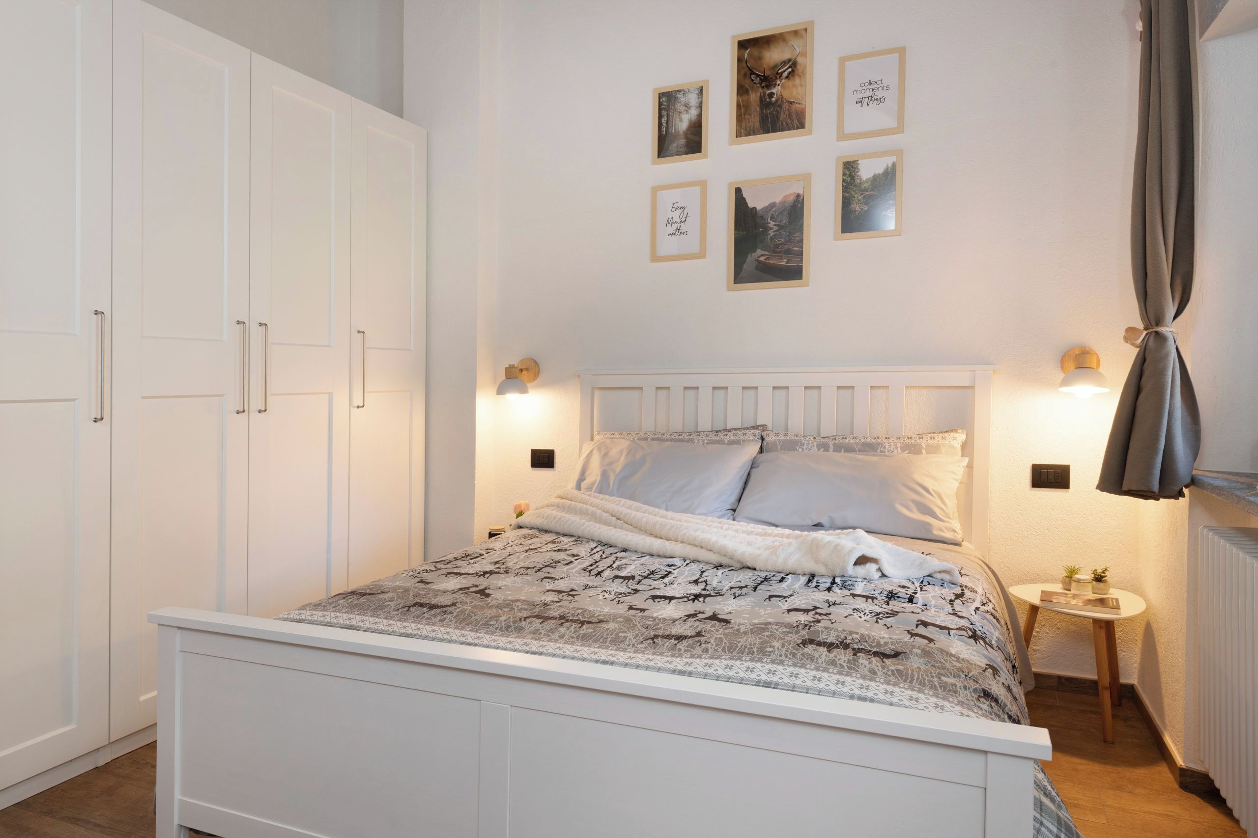 Une chambre à coucher comprenant un lit, une armoire, une table de chevet et des œuvres d’art accrochées au mur.