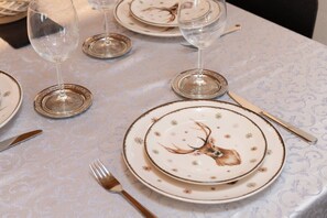 A table set with plates, cutlery, and wine glasses, indicating a formal dining arrangement. - Rosa Canina - three-room apartment with balcony (Roisan)