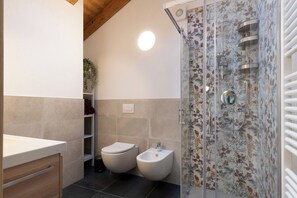 A bathroom with a shower, toilet, bidet, and a sink. - Rosa Canina - three-room apartment with balcony (Roisan)