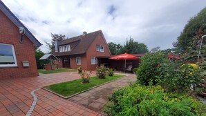 Een woonwijk met een verharde oprit naar een huis met een rood dak.
