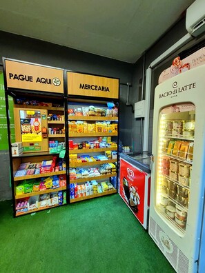 Ein Selbstbedienungskiosk mit einem gekühlten Ausstellungsbereich und Regalen, gefüllt mit verschiedenen Produkten.