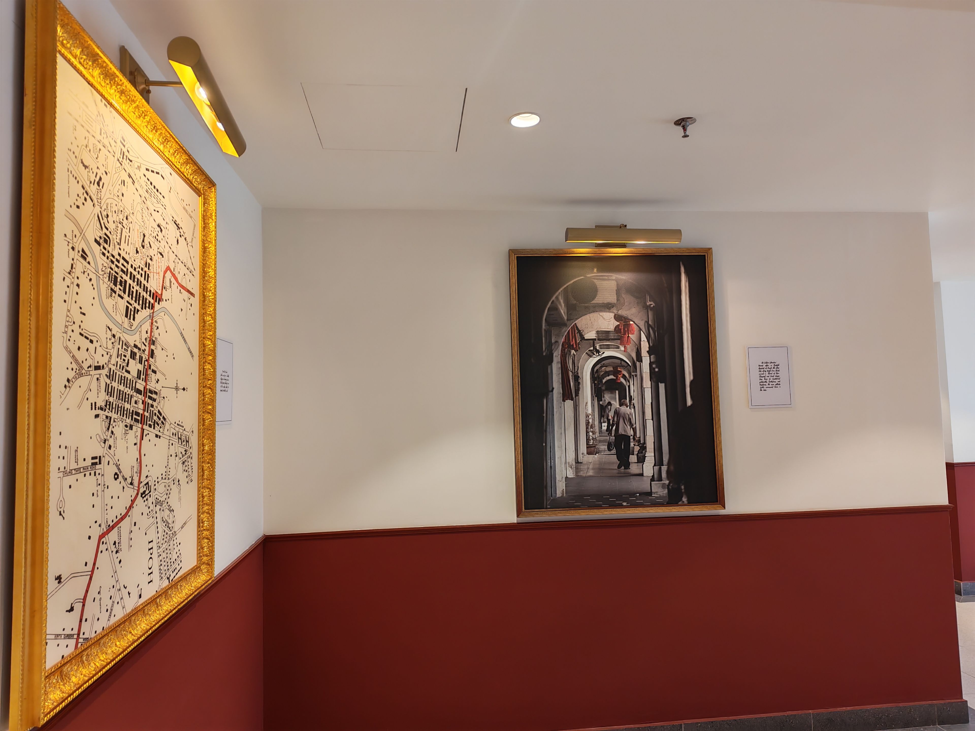 A hallway with a large map and a framed photograph on the walls.
