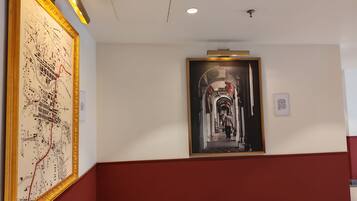 A hallway with a large map and a framed photograph on the walls.