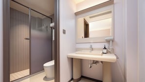 Une salle de bain moderne équipée de toilettes, d’un lavabo et d’une douche.