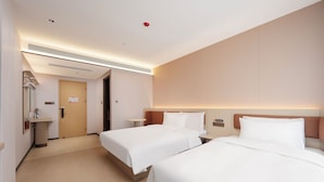 Une chambre d’hôtel avec deux lits, une salle de bain et une petite table.