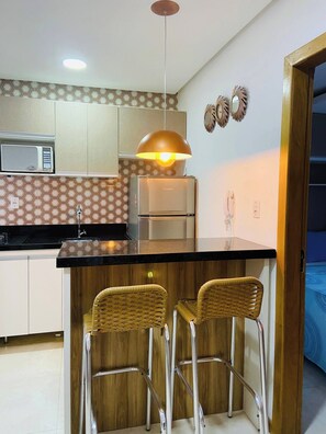 A modern kitchen with a central island, stainless steel appliances, and a hanging pendant light. - Apartment 101 · 101 Flat Good taste and quality (Belém)
