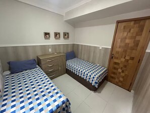 A bedroom with two beds, a dresser, and a door. - 102 Welcoming and cozy (Belém)