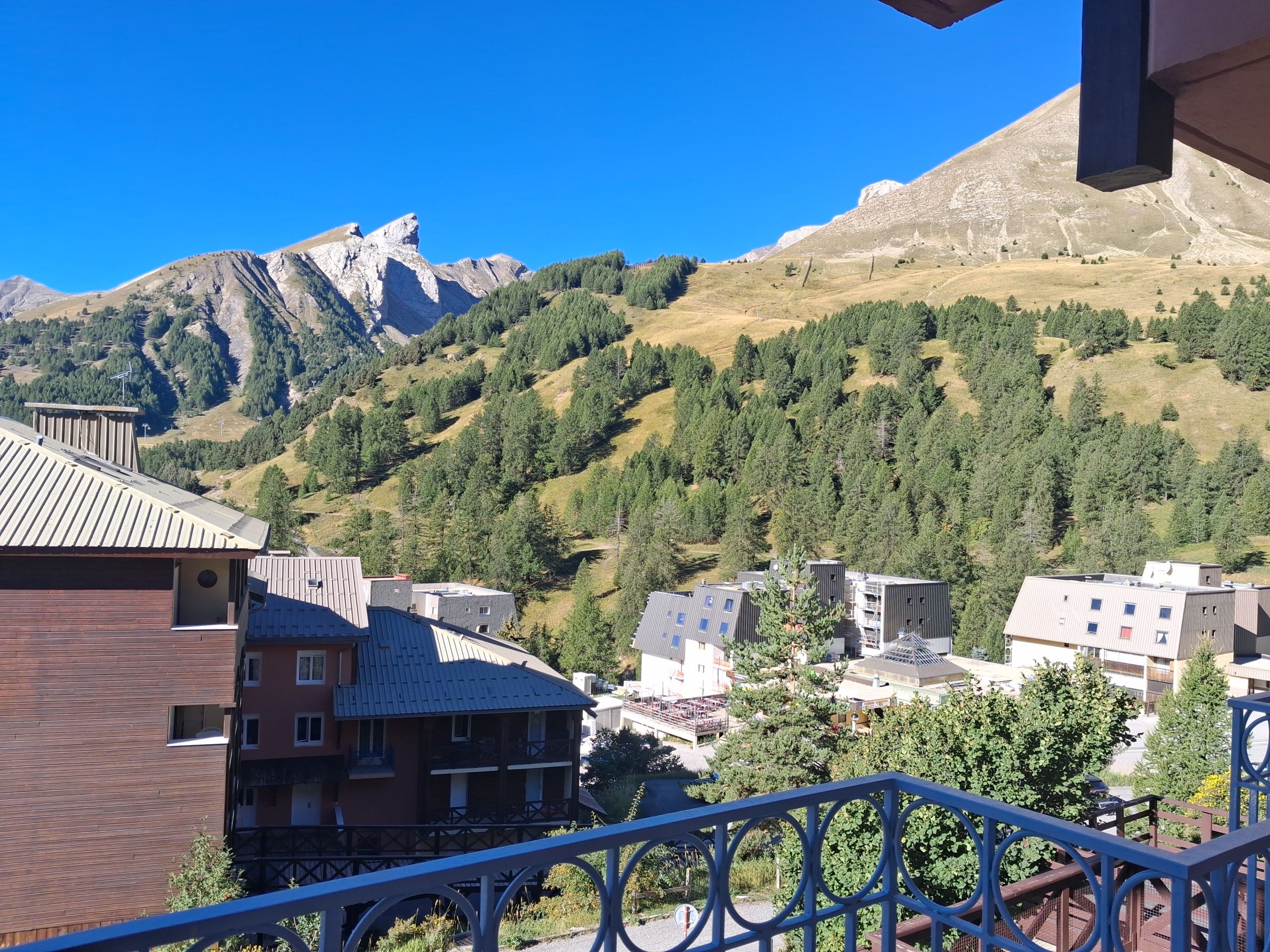 Un village de montagne avec des bâtiments et un sommet imposant en arrière-plan.