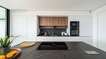 A modern kitchen with a dark countertop, wooden cabinets, and a built-in oven.