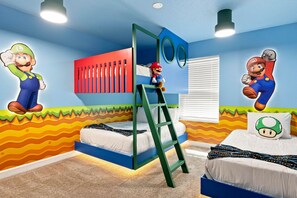A child's bedroom with a bunk bed, a ladder, and wall decorations of Mario and Luigi characters. - Chic Disney Retreat with Fun Themed Rooms (Four Corners)
