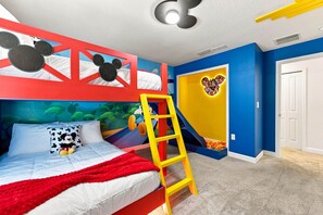 A child's bedroom with a bunk bed, a slide, and a Mickey Mouse-themed wall. - Chic Disney Retreat with Fun Themed Rooms (Four Corners)