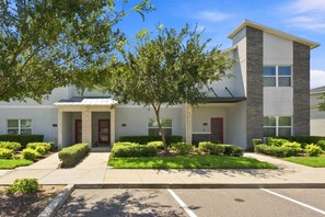 A modern building with a flat roof, a stone facade, and a covered entrance. - Chic Disney Retreat with Fun Themed Rooms (Four Corners)
