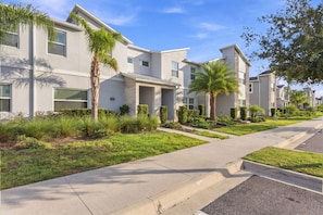 A modern residential building with a flat roof, large windows, and a well-maintained lawn. - Themed Disney Getaway, Pool & Amazing Location (Four Corners)