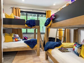 A bunk bed room with a window, a bicycle, and a helmet on the bed. - Sleeps 18 | 2 Hot Tubs, Sauna & Game Room (Winter Park)
