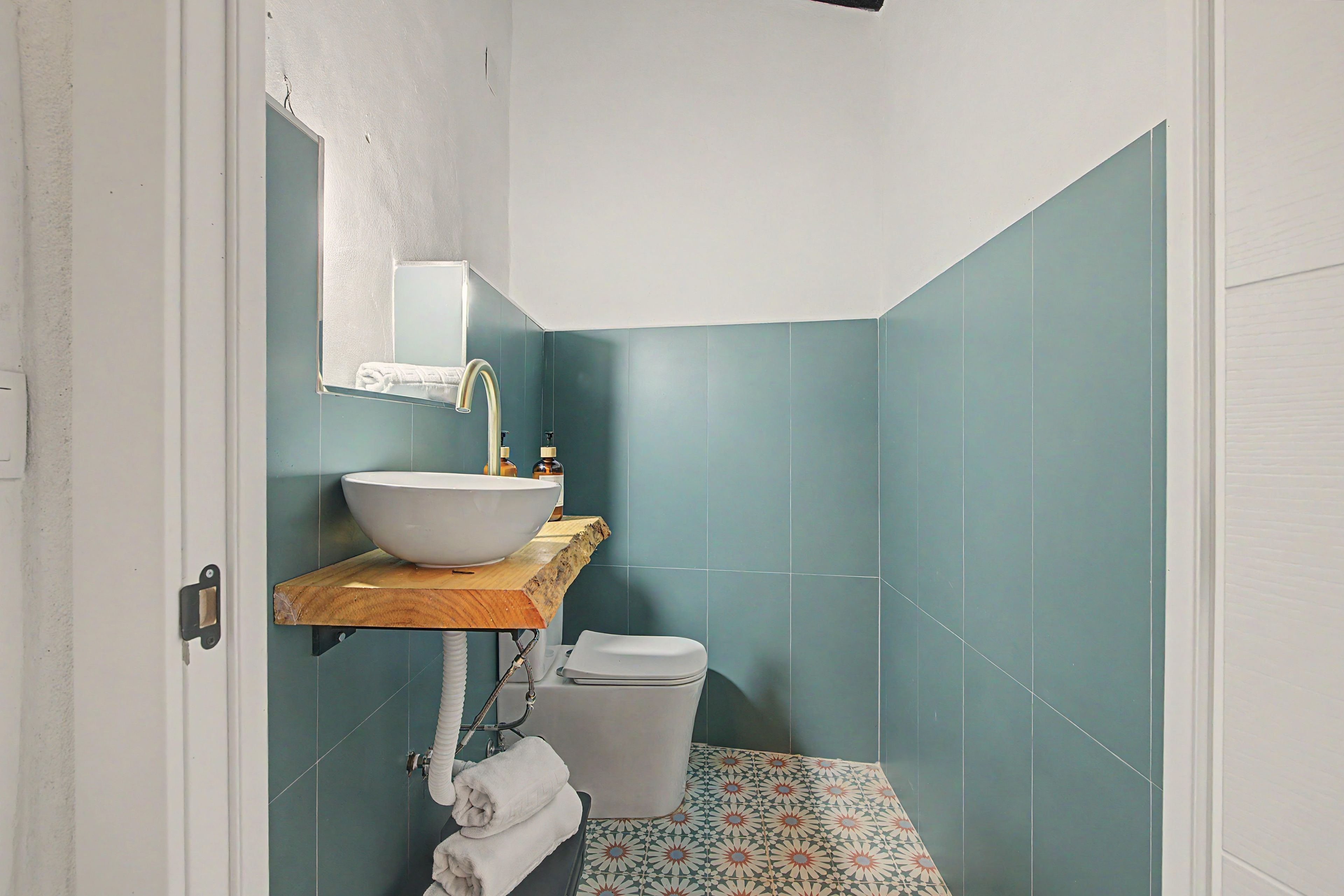 Un baño con un lavamanos blanco, un espejo y un inodoro.