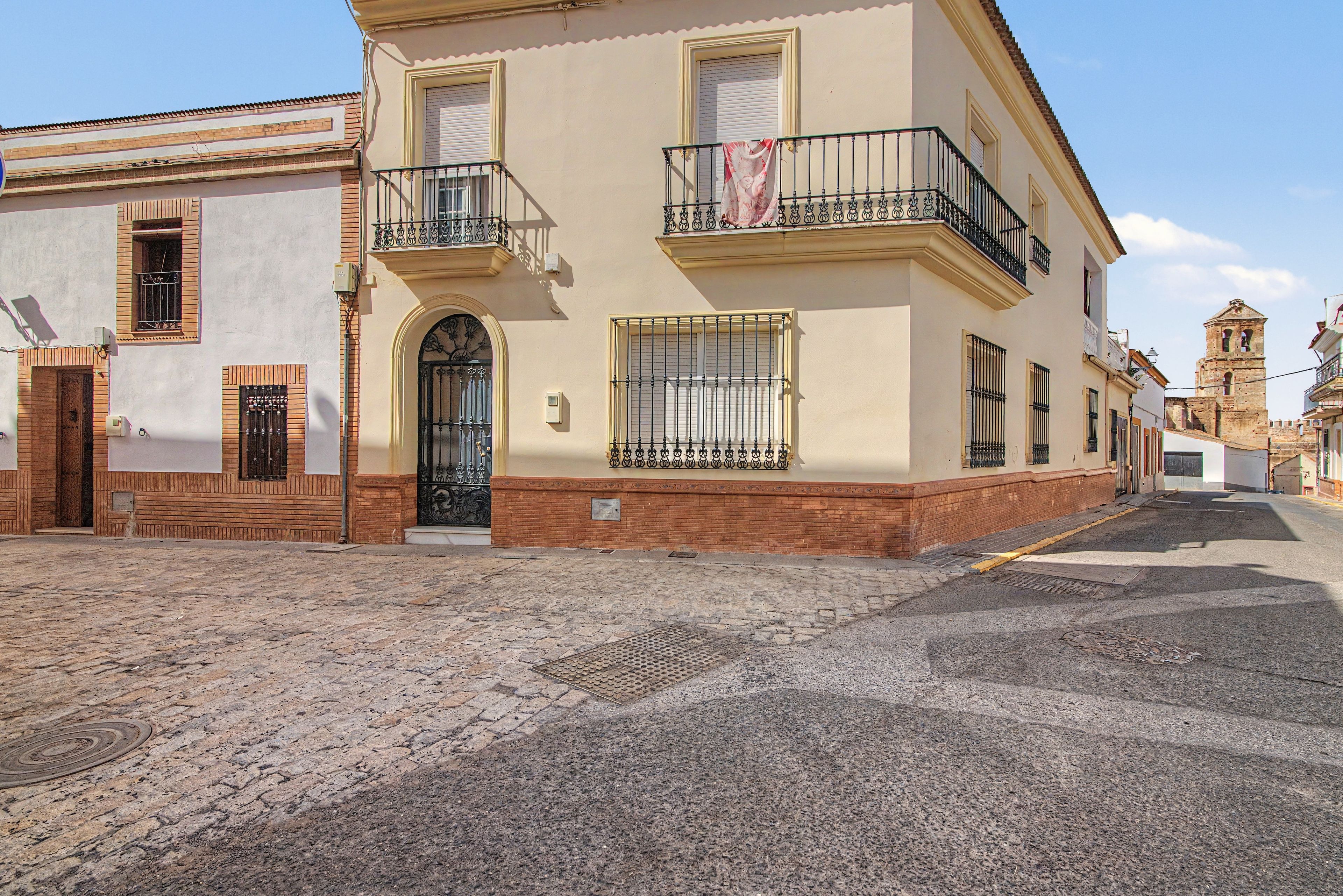 A building with a traditional facade, a gated entrance, and a cobblestone street.