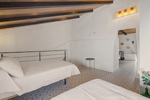 A bedroom with a bed, a small table, and a mirror. - Vacation Home 'La Casa del Castillo' with Private Terrace, Wi-Fi & Air Conditioning (Niebla)