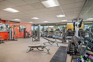 Ein Fitnessstudio mit unterschiedlichen Trainingsgeräten, darunter Laufbänder, Kraftgeräte und Kurzhanteln.