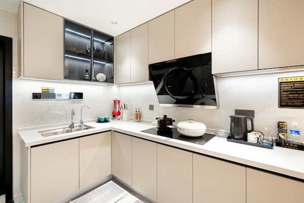 A modern kitchen with a built-in oven, a microwave, and a coffee machine.